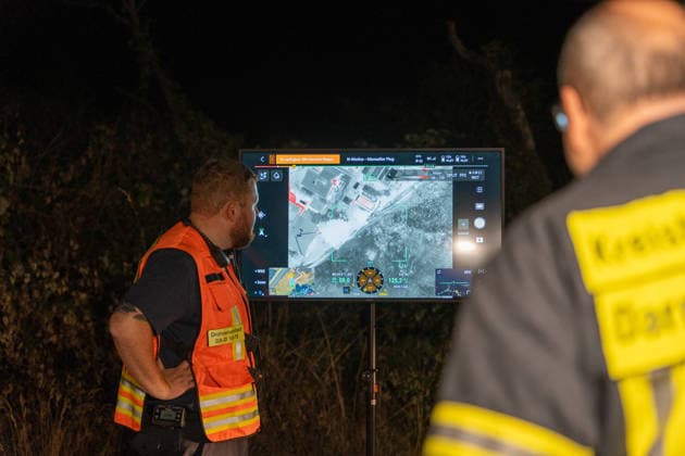 Großer Flächenbrand bedroht Wohngebiet Am 03.08.2026 gegen 02:00 Uhr brannten zwischen Seeheim-Jugenheim und Alsbach im Landkreis Darmstadt-Dieburg rund 28.000 Quadratmeter Feld und Gestrüpp entlang der L3100. Die Feuerwehr stoppte die Flammen etwa fünf Meter vor angrenzenden Wohnhäusern. Ein Anwohner erlitt beim eigenständigen Löschversuch eine Rauchgasvergiftung und wurde vom Rettungsdienst in ein Krankenhaus gebracht. Die Straßenbahnstrecke zwischen Alsbach und Seeheim-Jugenheim wurde gesperrt, ein Schienenersatzverkehr eingerichtet. Zur Brandbekämpfung kam eine Drohne mit Wärmebildkamera zum Aufspüren von Glutnestern zum Einsatz. Seeheim-Jugenheim Hessen Deutschland *** Large Wildfire Threatens Residential Area On August 3,
