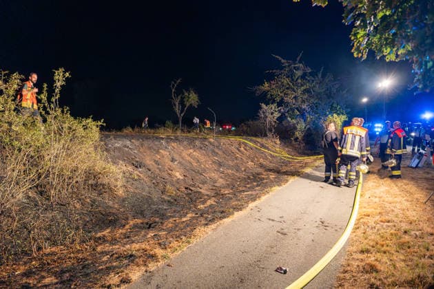 Großer Flächenbrand bedroht Wohngebiet Am 03.08.2026 gegen 02:00 Uhr brannten zwischen Seeheim-Jugenheim und Alsbach im Landkreis Darmstadt-Dieburg rund 28.000 Quadratmeter Feld und Gestrüpp entlang der L3100. Die Feuerwehr stoppte die Flammen etwa fünf Meter vor angrenzenden Wohnhäusern. Ein Anwohner erlitt beim eigenständigen Löschversuch eine Rauchgasvergiftung und wurde vom Rettungsdienst in ein Krankenhaus gebracht. Die Straßenbahnstrecke zwischen Alsbach und Seeheim-Jugenheim wurde gesperrt, ein Schienenersatzverkehr eingerichtet. Zur Brandbekämpfung kam eine Drohne mit Wärmebildkamera zum Aufspüren von Glutnestern zum Einsatz. Seeheim-Jugenheim Hessen Deutschland *** Large Wildfire Threatens Residential Area On August 3,