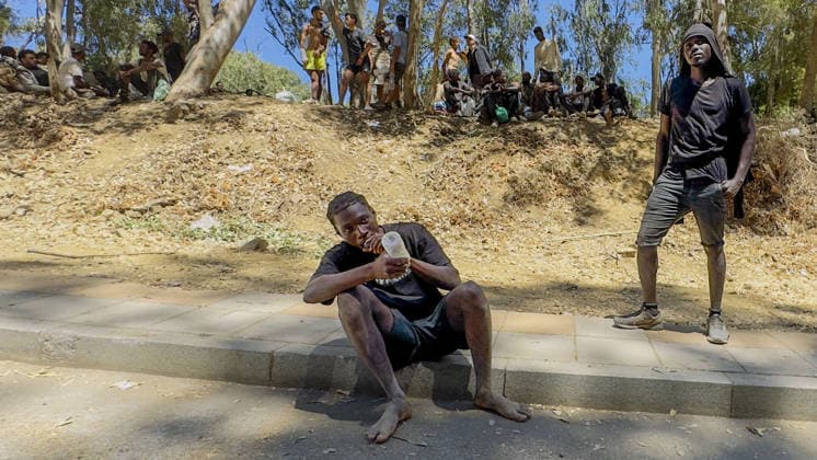 Migrant crisis in Cueta An unprecedented border crisis has hit the Spanish North African enclave of Ceuta, where an estimated 60,000 migrants crossed from Morocco. Pictured. African migrants resting on the street. 02.08.2026  Copyright: xIanxWhittakerx NINTCHDBPICT001099189075