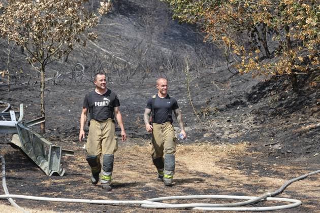 Firefighters pictured at the scene of a brush fire along the E25 highway in Bastogne, on Monday 03 August 2026. A major brush fire broke out Monday morning in the municipality of Bastogne, near the Withimont highway rest area.  JULIENxWARNAND 182681985