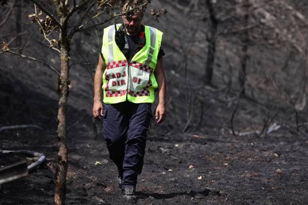 Firefighters pictured at the scene of a brush fire along the E25 highway in Bastogne, on Monday 03 August 2026. A major brush fire broke out Monday morning in the municipality of Bastogne, near the Withimont highway rest area.  JULIENxWARNAND 182681989