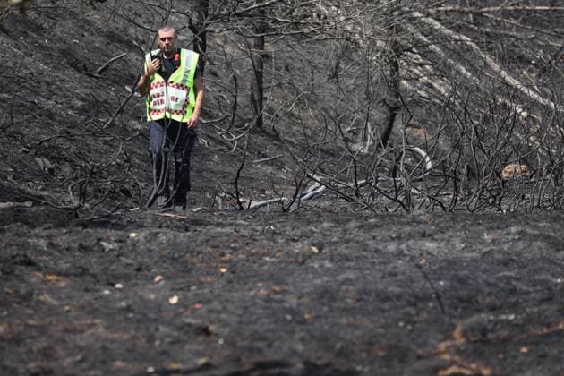 Firefighters pictured at the scene of a brush fire along the E25 highway in Bastogne, on Monday 03 August 2026. A major brush fire broke out Monday morning in the municipality of Bastogne, near the Withimont highway rest area.  JULIENxWARNAND 182681996