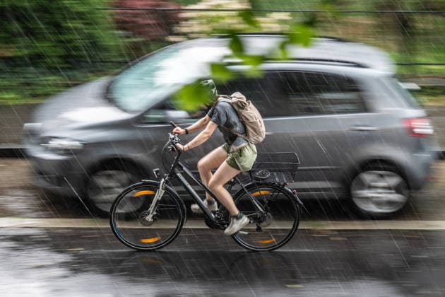 Starkregen in Göttingen 03.08.2026, Göttingen --- Eine Radfahrerin fährt während eines Starkregens durch eine Straße in Göttingen. Göttingen Niedersachsen Deutschland *** Heavy Rain in Göttingen, August 3, 2026; Göttingen: A cyclist rides down a street in Göttingen during a heavy rainstorm. Göttingen, Lower Saxony, Germany