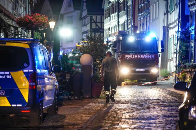 Feuer im Dachgeschoss eines Fachwerkhauses Flammen schlagen aus dem Fenster Feuerwehr riegelt enge Altstadt ab Am 03.08.2026 brannte gegen 21:00 Uhr ein Fachwerkhaus in der Oberstadt 18 in der Altstadt von Lich. Der Brand betraf das Obergeschoss und den Dachbereich des Gebäudes, es kam zu starker Rauchentwicklung und Flammenaustritt. Beim Eintreffen der Feuerwehr befand sich niemand mehr im Gebäude. Die Freiwillige Feuerwehr Lich leitete Außen- und Innenangriff ein und baute wegen der engen Altstadtbebauung eine Riegelstellung mit der Drehleiter zum Schutz der Nachbarhäuser auf. Lich Hessen Deutschland *** Fire in the attic of a half-timbered house; flames are shooting out of the window; firefighters cordon off the narrow old t