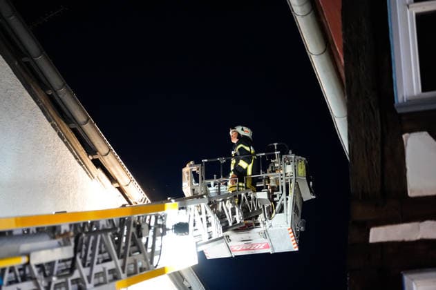 Feuer im Dachgeschoss eines Fachwerkhauses Flammen schlagen aus dem Fenster Feuerwehr riegelt enge Altstadt ab Am 03.08.2026 brannte gegen 21:00 Uhr ein Fachwerkhaus in der Oberstadt 18 in der Altstadt von Lich. Der Brand betraf das Obergeschoss und den Dachbereich des Gebäudes, es kam zu starker Rauchentwicklung und Flammenaustritt. Beim Eintreffen der Feuerwehr befand sich niemand mehr im Gebäude. Die Freiwillige Feuerwehr Lich leitete Außen- und Innenangriff ein und baute wegen der engen Altstadtbebauung eine Riegelstellung mit der Drehleiter zum Schutz der Nachbarhäuser auf. Lich Hessen Deutschland *** Fire in the attic of a half-timbered house; flames are shooting out of the window; firefighters cordon off the narrow old t