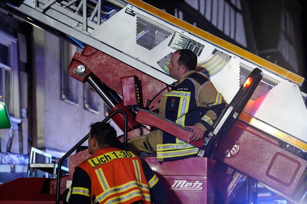 Feuer im Dachgeschoss eines Fachwerkhauses Flammen schlagen aus dem Fenster Feuerwehr riegelt enge Altstadt ab Am 03.08.2026 brannte gegen 21:00 Uhr ein Fachwerkhaus in der Oberstadt 18 in der Altstadt von Lich. Der Brand betraf das Obergeschoss und den Dachbereich des Gebäudes, es kam zu starker Rauchentwicklung und Flammenaustritt. Beim Eintreffen der Feuerwehr befand sich niemand mehr im Gebäude. Die Freiwillige Feuerwehr Lich leitete Außen- und Innenangriff ein und baute wegen der engen Altstadtbebauung eine Riegelstellung mit der Drehleiter zum Schutz der Nachbarhäuser auf. Lich Hessen Deutschland *** Fire in the attic of a half-timbered house; flames are shooting out of the window; firefighters cordon off the narrow old t