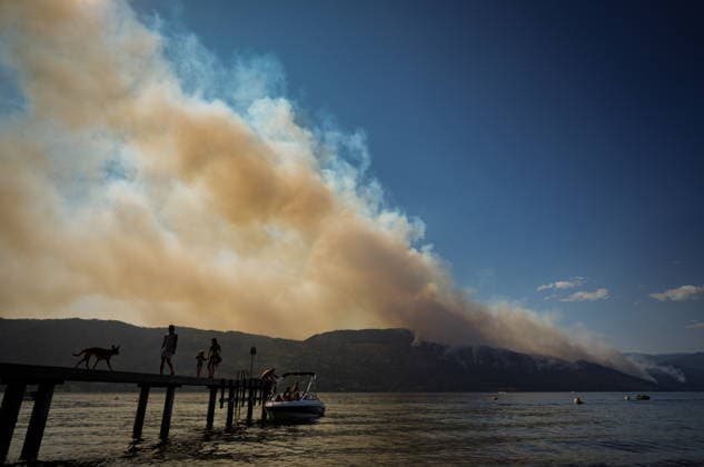 August 3, 2026, Lake Country, Bc, CANADA: People and a dog are silhouetted while walking on a dock as on Okanagan Lake, in Lake Country, B.C., as the Quilpituk Creek wildfire burns on the mountainside across the lake in near Fintry, on Monday, Aug. 3, 2026. Lake Country CANADA  - ZUMAc35_ 20260803_zaf_c35_058 Copyright: xDarrylxDyckx