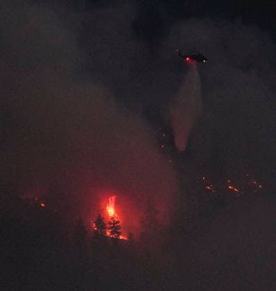 August 3, 2026, West Kelowna, Bc, CANADA: A helicopter conducting night operations drops water on the Quilpituk Creek wildfire burning on the west side of Okanagan Lake near Fintry, B.C., late Monday, August 3, 2026. West Kelowna CANADA  - ZUMAc35_ 20260803_zaf_c35_107 Copyright: xDarrylxDyckx