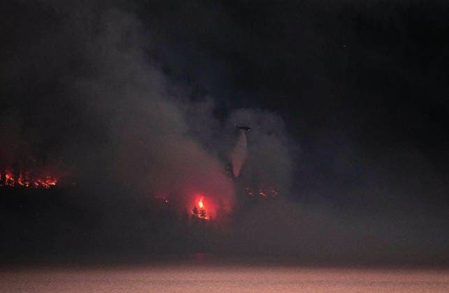 August 3, 2026, West Kelowna, Bc, CANADA: A helicopter conducting night operations drops water on the Quilpituk Creek wildfire burning on the west side of Okanagan Lake near Fintry, B.C., late Monday, August 3, 2026. West Kelowna CANADA  - ZUMAc35_ 20260803_zaf_c35_108 Copyright: xDarrylxDyckx