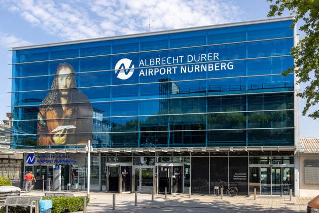 Baustart Cargo ‹Center 3 am Flughafen Nürnberg, Nürnberg, 04.08.2026 Das Terminalgebäude des Albrecht Dürer Airport Nürnberg zeigt ein großformatiges Porträt von Albrecht Dürer an der Fassade. Der Flughafen erweitert seinen Cargo-Bereich und startet den Bau des neuen Cargo Centers 3 (CCN 3), um der anhaltend hohen Nachfrage nach Logistikflächen gerecht zu werden. Nürnberg Flughafen Bayern Deutschland *** Construction Begins on Cargo Center 3 at Nuremberg Airport, Nuremberg, August 4, 2026 The terminal building at Albrecht Dürer Airport Nuremberg features a large-scale portrait of Albrecht Dürer on its facade. The airport is expanding its cargo area and beginning construction of the new Cargo Center 3 (CCN 3), to meet the consist 20260804-286A4222-M4000