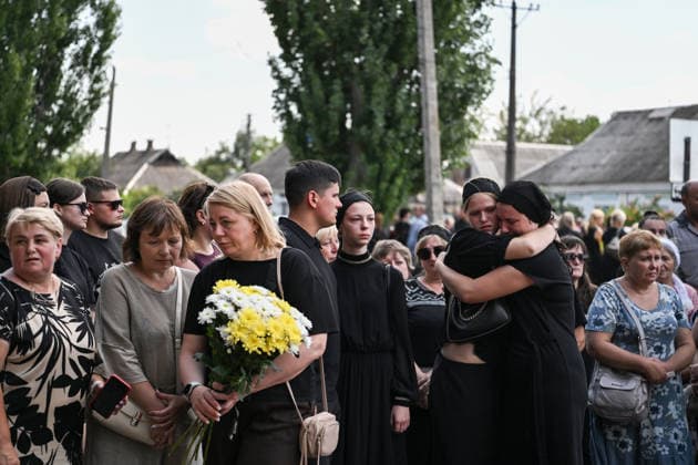 People pay their last respects to members of the Voronov family, killed when a Russian Iskander-M ballistic missile directly struck their home on the night of Thursday, July 30, Radushne settlement, Kryvyi Rih district, Dnipropetrovsk region, Ukraine, August 3, 2026. Five family members whose identities have been officially confirmed were laid to rest: parents Artem, 47, and Olena, 41, together with their children Mark, 17, Azarii Ilai, 11, and Emiliia, 6. Five other children who were in the house that night - Zakhar, Dominika, Viorika, Federika and one-and-a-half-year-old grandson Artem - are still officially listed as missing. Rescuers recovered 17 body fragments from the rubble, and complex forensic DNA examinations are under way to iden  Copyright: xDmytroxSmolienkox