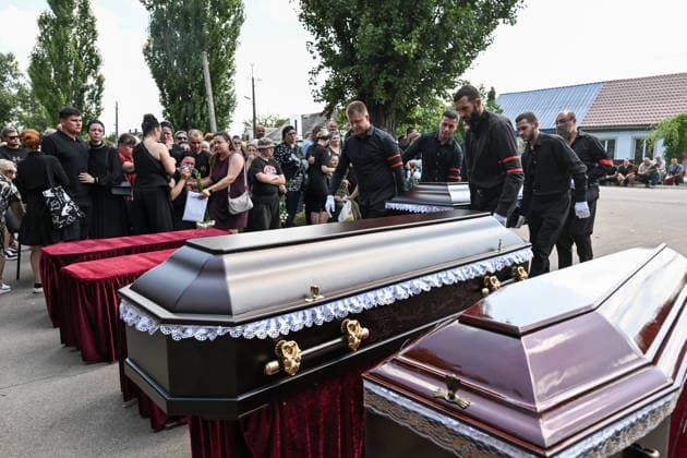 Men carry the coffin as people pay their last respects to members of the Voronov family, killed when a Russian Iskander-M ballistic missile directly struck their home on the night of Thursday, July 30, Radushne settlement, Kryvyi Rih district, Dnipropetrovsk region, Ukraine, August 3, 2026. Five family members whose identities have been officially confirmed were laid to rest: parents Artem, 47, and Olena, 41, together with their children Mark, 17, Azarii Ilai, 11, and Emiliia, 6. Five other children who were in the house that night - Zakhar, Dominika, Viorika, Federika and one-and-a-half-year-old grandson Artem - are still officially listed as missing. Rescuers recovered 17 body fragments from the rubble, and complex forensic DNA examinatio  Copyright: xDmytroxSmolienkox