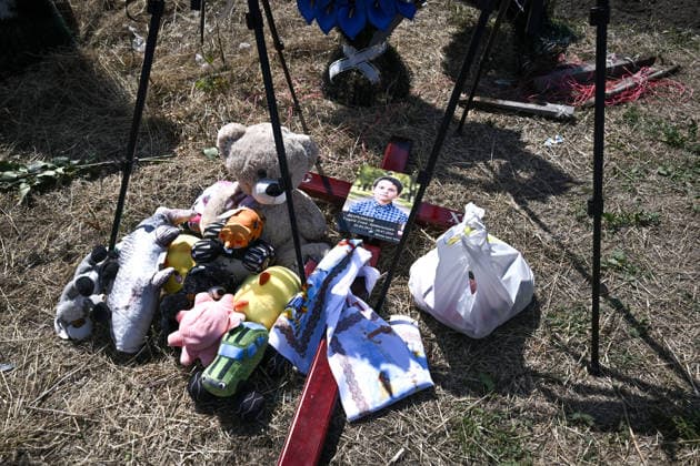 Toys are left on the ground by the cross with the photo of Azarii Ilai, 11, during the funeral of members of the Voronov family, killed when a Russian Iskander-M ballistic missile directly struck their home on the night of Thursday, July 30, Radushne settlement, Kryvyi Rih district, Dnipropetrovsk region, Ukraine, August 3, 2026. Five family members whose identities have been officially confirmed were laid to rest: parents Artem, 47, and Olena, 41, together with their children Mark, 17, Azarii Ilai, 11, and Emiliia, 6. Five other children who were in the house that night - Zakhar, Dominika, Viorika, Federika and one-and-a-half-year-old grandson Artem - are still officially listed as missing. Rescuers recovered 17 body fragments from the rub  Copyright: xDmytroxSmolienkox
