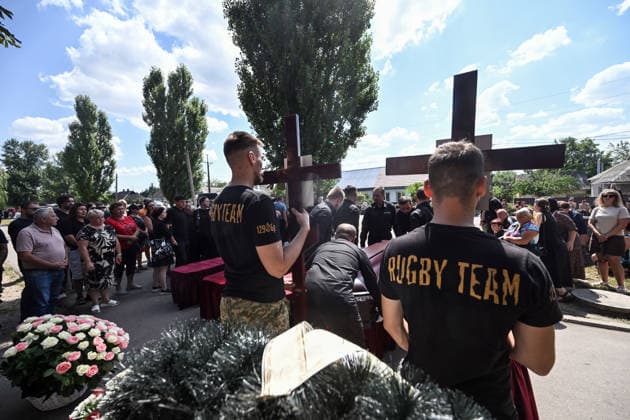 Men hold crosses as people pay their last respects to members of the Voronov family, killed when a Russian Iskander-M ballistic missile directly struck their home on the night of Thursday, July 30, Radushne settlement, Kryvyi Rih district, Dnipropetrovsk region, Ukraine, August 3, 2026. Five family members whose identities have been officially confirmed were laid to rest: parents Artem, 47, and Olena, 41, together with their children Mark, 17, Azarii Ilai, 11, and Emiliia, 6. Five other children who were in the house that night - Zakhar, Dominika, Viorika, Federika and one-and-a-half-year-old grandson Artem - are still officially listed as missing. Rescuers recovered 17 body fragments from the rubble, and complex forensic DNA examinations a  Copyright: xDmytroxSmolienkox