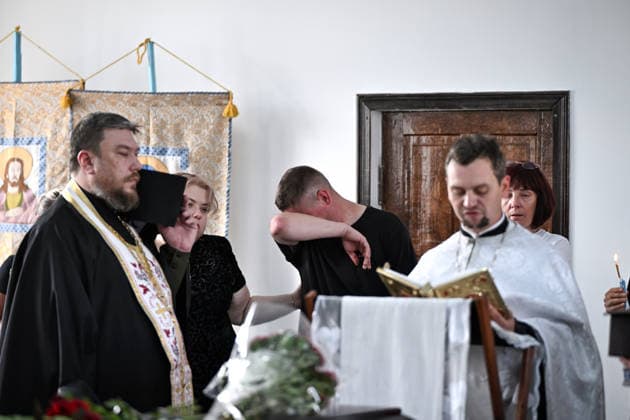 A man wipes tears with an arm during a funeral service for members of the Voronov family, killed when a Russian Iskander-M ballistic missile directly struck their home on the night of Thursday, July 30, Radushne settlement, Kryvyi Rih district, Dnipropetrovsk region, Ukraine, August 3, 2026. Five family members whose identities have been officially confirmed were laid to rest: parents Artem, 47, and Olena, 41, together with their children Mark, 17, Azarii Ilai, 11, and Emiliia, 6. Five other children who were in the house that night - Zakhar, Dominika, Viorika, Federika and one-and-a-half-year-old grandson Artem - are still officially listed as missing. Rescuers recovered 17 body fragments from the rubble, and complex forensic DNA examinati  Copyright: xDmytroxSmolienkox