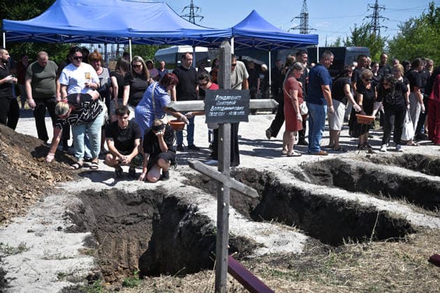A woman cries by the edge of the grave during the funeral of members of the Voronov family, killed when a Russian Iskander-M ballistic missile directly struck their home on the night of Thursday, July 30, Radushne settlement, Kryvyi Rih district, Dnipropetrovsk region, Ukraine, August 3, 2026. Five family members whose identities have been officially confirmed were laid to rest: parents Artem, 47, and Olena, 41, together with their children Mark, 17, Azarii Ilai, 11, and Emiliia, 6. Five other children who were in the house that night - Zakhar, Dominika, Viorika, Federika and one-and-a-half-year-old grandson Artem - are still officially listed as missing. Rescuers recovered 17 body fragments from the rubble, and complex forensic DNA examina  Copyright: xDmytroxSmolienkox