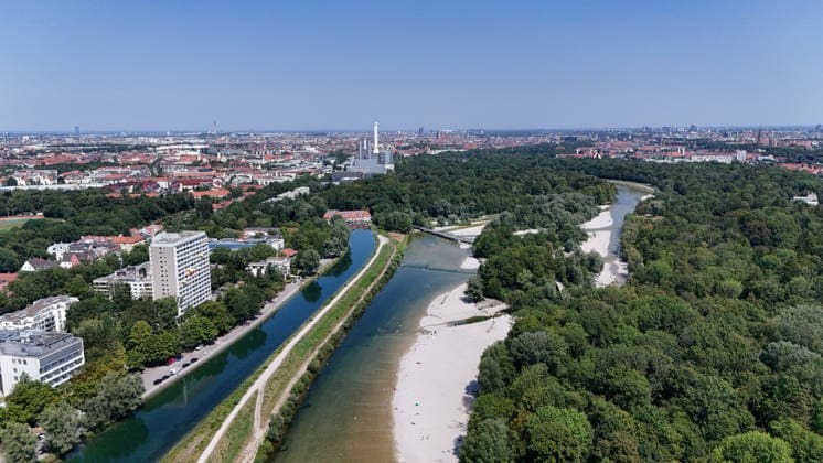 Ein Sommertag in der Landeshauptstadt München. Hier der Blick auf die auf die Isar und den Isar Werkskanal (li.) sowie den Flaucher, Badegelände, Kiesstrand, sowie die Skyline der Stadt München mit Blick Richtung Norden, Stadtblick, Häusermeer, Erholungsgebiet, Sonnen, baden, Abkühlen *** A summer day in Munich, the state capital. Here is a view of the Isar River and the Isar Werkskanal, as well as the Flaucher—a swimming area, pebble beach, and the Munich skyline—looking north: cityscape, sea of buildings, recreational area, sunbathing, swimming, cooling off