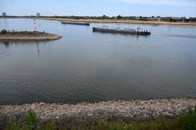 Historisches Niedrigwasser im Rhein, die Wasserschutzpolizei Duesseldorf meldet mit 23cm den niedrigsten in Duesseldorf gemessenen Rheinpegel, Tiefer Wasserstand, steiniges Flussufer, eine weit aufragende rote Ufermarkierung, im Hintergrund begegnen sich zwei Frachtschiffe, Duesseldorf, 04.08.2026 *** Historically low water levels on the Rhine; the Düsseldorf Water Police report that the Rhine’s water level in Düsseldorf has reached 23 cm—the lowest ever recorded there. Low water level, rocky riverbank, a tall red bank marker; in the background, two cargo ships pass each other. Düsseldorf, August 4, 2026