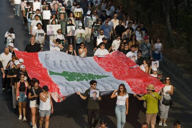 Beirut Port Explosion Commemoration BEIRUT, LEBANON - August 4: Marches carry a Lebanese flag as they walk to the port during commemorations for the sixth anniversary of the Beirut Port explosion. Beirut LB Copyright: x xNicholasxFrakesx xJNAxPressx