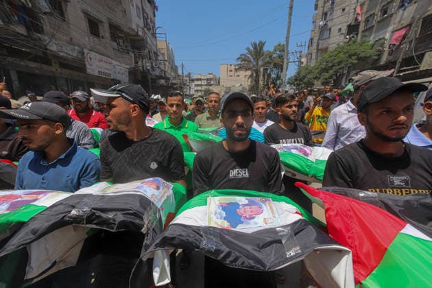 Gaza City Mass Funeral August 3 2026 Mourners carry bodies wrapped in Palestinian flags and adorned with photographs during a mass funeral procession in the Al-Sabra neighborhood of Gaza City, Gaza Strip, on August 4, 2026. The remains of 112 members of the Abu Sharia and Al-Hasayneh families were recovered from the rubble of their home following an Israeli strike. Relatives stated the attack claimed the lives of more than 300 people. The bodies were buried at Al-Maamadani Cemetery as military operations continue across the territory. Gaza Gaza Strip Palestinian Territories Copyright: xRamezxHabboubx