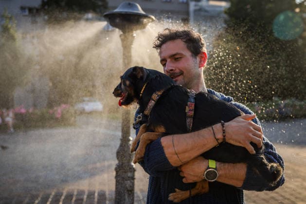 Another Heat Wave In Poland A man with a dog cool down by a water sprinkler at the Podgorski Square in Krakow, Poland on August 4th, 2026. An intense heat wave is peaking in Poland with temperatures hitting up to 40Â°C and driving an extreme risk of wildfires across Europe. Krakow Poland  Copyright: xBeataxZawrzelx originalFilename: zawrzel-anotherh260804_npuLK.jpg
