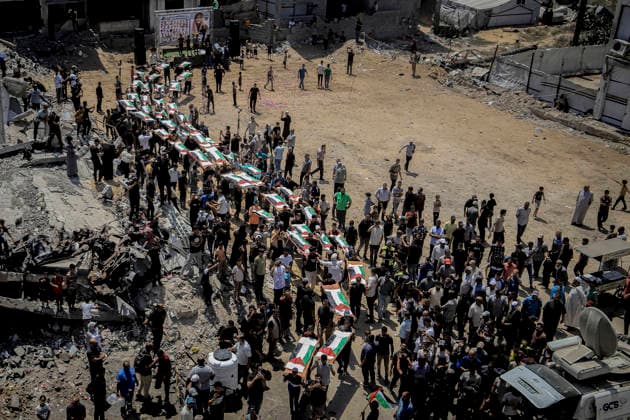 Gaza City Mass Funeral August 3 2026 Mourners carry bodies wrapped in Palestinian flags on stretchers during a mass funeral procession in the Al-Sabra neighborhood of Gaza City, Gaza Strip, on August 4, 2026. The remains of 112 members of the Abu Sharia and Al-Hasayneh families were recovered from the rubble of their home following an Israeli strike. Relatives stated the attack claimed the lives of more than 300 people. The bodies were buried at Al-Maamadani Cemetery as military operations continue across the territory. Gaza Gaza Strip Palestinian Territories Copyright: xMohammedxMxSkaikx