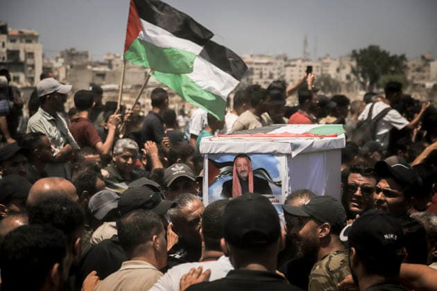 Gaza City Mass Funeral August 3 2026 Mourners carry a coffin bearing a photograph overhead during a mass funeral procession in the Al-Sabra neighborhood of Gaza City, Gaza Strip, on August 4, 2026. The remains of 112 members of the Abu Sharia and Al-Hasayneh families were recovered from the rubble of their home following an Israeli strike. Relatives stated the attack claimed the lives of more than 300 people. The bodies were buried at Al-Maamadani Cemetery as military operations continue across the territory. Gaza Gaza Strip Palestinian Territories Copyright: xMohammedxMxSkaikx