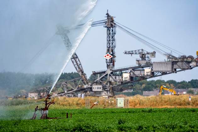 Künstliche Bewässerung eines Möhren Feldes mit einer Beregnungsanlage, lange Trockenheit im Sommer macht dies notwendig um die Ernte zu sichern, bei Erkelenz-Holzweiler, am Braunkohletagebau Garzweiler, Braunkohlebagger, NRW, Deutschland Künstliche Bewässerung *** Artificial irrigation of a carrot field using a sprinkler system; a prolonged summer drought makes this necessary to ensure the harvest, near Erkelenz-Holzweiler, at the Garzweiler open-pit lignite mine, lignite excavators, North Rhine-Westphalia, Germany; Artificial irrigation