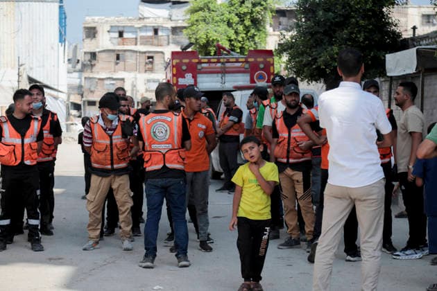 Gaza City Mass Funeral August 3 2026 Palestinian civil defense workers gather in a street during a mass funeral procession in the Al-Sabra neighborhood of Gaza City, Gaza Strip, on August 4, 2026. The remains of 112 members of the Abu Sharia and Al-Hasayneh families were recovered from the rubble of their home following an Israeli strike. Relatives stated the attack claimed the lives of more than 300 people. The bodies were buried at Al-Maamadani Cemetery as military operations continue across the territory. Gaza Gaza Strip Palestinian Territories Copyright: xEyadxAzamx