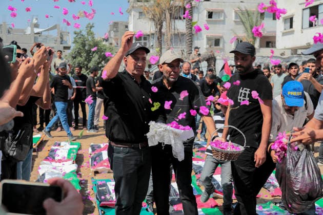 Gaza City Mass Funeral August 3 2026 Men throw flower petals over bodies wrapped in Palestinian flags during a mass funeral procession in the Al-Sabra neighborhood of Gaza City, Gaza Strip, on August 4, 2026. The remains of 112 members of the Abu Sharia and Al-Hasayneh families were recovered from the rubble of their home following an Israeli strike. Relatives stated the attack claimed the lives of more than 300 people. The bodies were buried at Al-Maamadani Cemetery as military operations continue across the territory. Gaza Gaza Strip Palestinian Territories Copyright: xEyadxAzamx