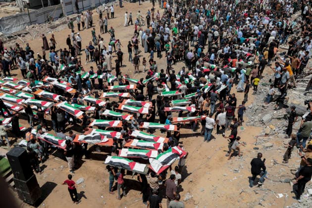 Gaza City Mass Funeral August 3 2026 Mourners carry bodies wrapped in Palestinian flags during a mass funeral procession in the Al-Sabra neighborhood of Gaza City, Gaza Strip, on August 4, 2026. The remains of 112 members of the Abu Sharia and Al-Hasayneh families were recovered from the rubble of their home following an Israeli strike. Relatives stated the attack claimed the lives of more than 300 people. The bodies were buried at Al-Maamadani Cemetery as military operations continue across the territory. Gaza Gaza Strip Palestinian Territories Copyright: xEyadxAzamx