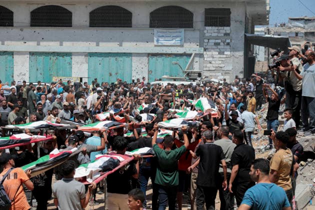 Gaza City Mass Funeral August 3 2026 Mourners carry bodies wrapped in Palestinian flags during a mass funeral procession in the Al-Sabra neighborhood of Gaza City, Gaza Strip, on August 4, 2026. The remains of 112 members of the Abu Sharia and Al-Hasayneh families were recovered from the rubble of their home following an Israeli strike. Relatives stated the attack claimed the lives of more than 300 people. The bodies were buried at Al-Maamadani Cemetery as military operations continue across the territory. Gaza Gaza Strip Palestinian Territories Copyright: xEyadxAzamx