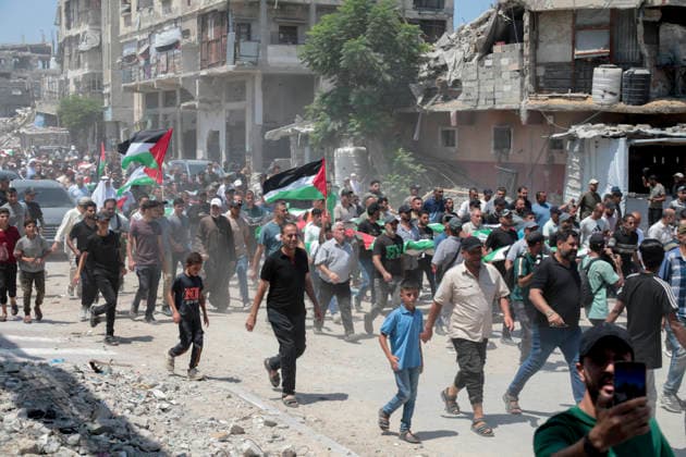 Gaza City Mass Funeral August 3 2026 Mourners carry bodies wrapped in Palestinian flags during a mass funeral procession in the Al-Sabra neighborhood of Gaza City, Gaza Strip, on August 4, 2026. The remains of 112 members of the Abu Sharia and Al-Hasayneh families were recovered from the rubble of their home following an Israeli strike. Relatives stated the attack claimed the lives of more than 300 people. The bodies were buried at Al-Maamadani Cemetery as military operations continue across the territory. Gaza Gaza Strip Palestinian Territories Copyright: xEyadxAzamx