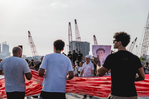 Beirut Port Blast Anniversary Commemoration Participants hold the edge of a large Lebanese flag during a commemoration marking the sixth anniversary of the Beirut Port explosion in Beirut, Lebanon, on August 4, 2026. The August 4, 2020 blast, caused by ammonium nitrate stored at the port, killed more than 200 people, injured thousands and devastated large parts of the Lebanese capital. Beirut Beirut Lebanon Copyright: xManonxRocax