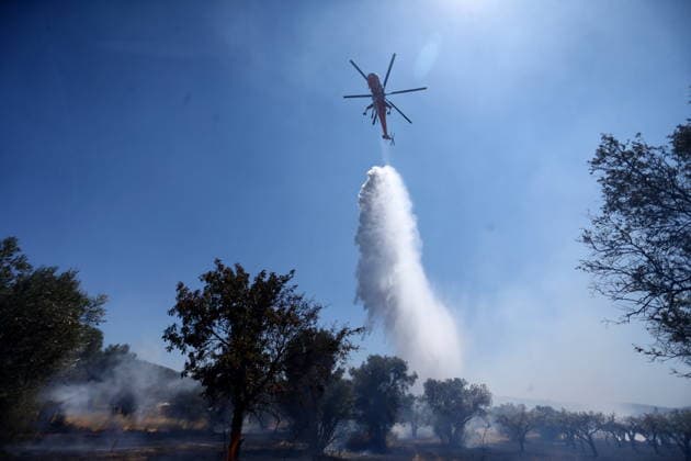 August 5, 2026, Koropi, Greece: Firefighters battle a wildfire in the Koropi area, southeast of Athens, as helicopters carry out repeated water drops to contain the flames. Ground crews worked alongside aerial firefighting units to prevent the fire from spreading amid dry conditions and strong winds. Koropi Greece  - ZUMAv62_ 20260805_zaf_v62_016 Copyright: xAristidisxVafeiadakisx