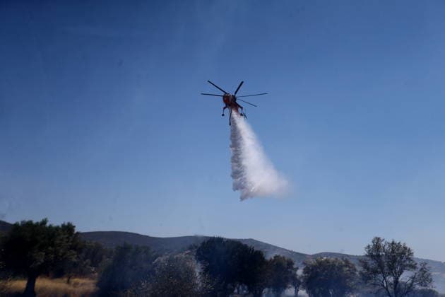 August 5, 2026, Koropi, Greece: Firefighters battle a wildfire in the Koropi area, southeast of Athens, as helicopters carry out repeated water drops to contain the flames. Ground crews worked alongside aerial firefighting units to prevent the fire from spreading amid dry conditions and strong winds. Koropi Greece  - ZUMAv62_ 20260805_zaf_v62_022 Copyright: xAristidisxVafeiadakisx