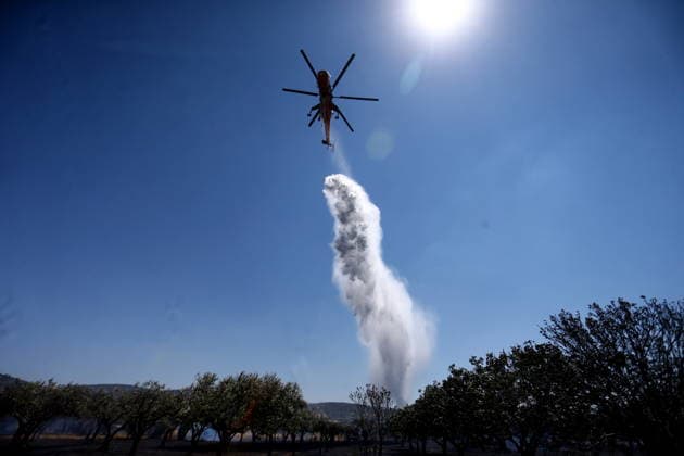 August 5, 2026, Koropi, Greece: Firefighters battle a wildfire in the Koropi area, southeast of Athens, as helicopters carry out repeated water drops to contain the flames. Ground crews worked alongside aerial firefighting units to prevent the fire from spreading amid dry conditions and strong winds. Koropi Greece  - ZUMAv62_ 20260805_zaf_v62_032 Copyright: xAristidisxVafeiadakisx