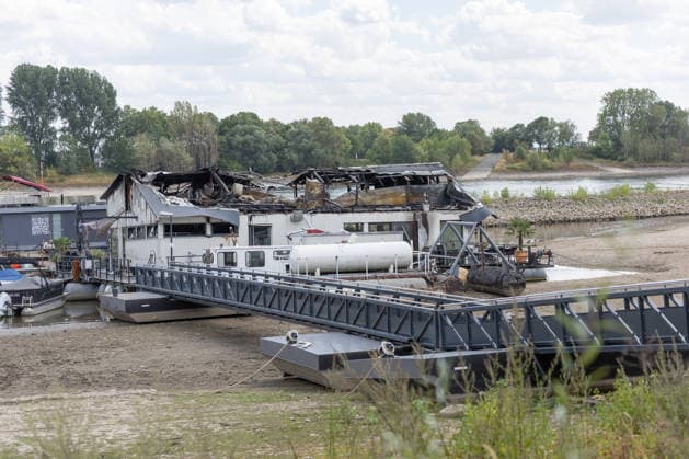 Sürther Bootshaus in Köln einen Tag nach dem Großbrand Ein Tag nach dem Großbrand: Das Sürther Bootshaus in Köln-Sürth, ein beliebtes Ausflugslokal und Restaurant direkt am Rhein, liegt in Trümmern bei dem Feuer am 04.08.2026 brannte vor allem der Dachbereich vollständig aus. Rund 100 Einsatzkräfte der Feuerwehr waren im Großeinsatz, verletzt wurde niemand, die Brandursache ist weiterhin unklar. Köln Sürth Nordrhein-Westfalen Deutschland *** The Sürth Boathouse in Cologne, One Day After the Major Fire One day after the major fire, the Sürth Boathouse in Cologne-Sürth, a popular destination for day trips and a restaurant right on the Rhine, lies in ruins following the fire on August 4, 2026. The roof area, in particular, bur Copyright: xMarcxJohnx