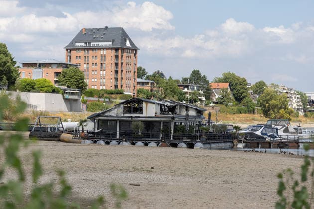 Sürther Bootshaus in Köln einen Tag nach dem Großbrand Ein Tag nach dem Großbrand: Das Sürther Bootshaus in Köln-Sürth, ein beliebtes Ausflugslokal und Restaurant direkt am Rhein, liegt in Trümmern bei dem Feuer am 04.08.2026 brannte vor allem der Dachbereich vollständig aus. Rund 100 Einsatzkräfte der Feuerwehr waren im Großeinsatz, verletzt wurde niemand, die Brandursache ist weiterhin unklar. Köln Sürth Nordrhein-Westfalen Deutschland *** The Sürth Boathouse in Cologne, One Day After the Major Fire One day after the major fire, the Sürth Boathouse in Cologne-Sürth, a popular destination for day trips and a restaurant right on the Rhine, lies in ruins following the fire on August 4, 2026. The roof area, in particular, bur Copyright: xMarcxJohnx