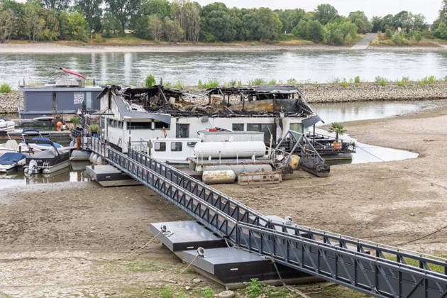 Sürther Bootshaus in Köln einen Tag nach dem Großbrand Ein Tag nach dem Großbrand: Das Sürther Bootshaus in Köln-Sürth, ein beliebtes Ausflugslokal und Restaurant direkt am Rhein, liegt in Trümmern bei dem Feuer am 04.08.2026 brannte vor allem der Dachbereich vollständig aus. Rund 100 Einsatzkräfte der Feuerwehr waren im Großeinsatz, verletzt wurde niemand, die Brandursache ist weiterhin unklar. Köln Sürth Nordrhein-Westfalen Deutschland *** The Sürth Boathouse in Cologne, One Day After the Major Fire One day after the major fire, the Sürth Boathouse in Cologne-Sürth, a popular destination for day trips and a restaurant right on the Rhine, lies in ruins following the fire on August 4, 2026. The roof area, in particular, bur Copyright: xMarcxJohnx
