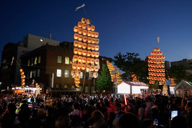 August 5, 2026, Akita, Japan: Visitors look at participants balancing bamboo poles adorned with paper lanterns (kanto) during the Akita Kanto Festival in Akita City. The annual event is one of the Tohoku region s three great festivals, where street performers skillfully balance over 270 towering bamboo poles (with the largest measuring 12 meters and weighing 50 kilograms) adorned with up to 46 candle-lit paper lanterns on their hands, shoulders, and foreheads to the rhythmic chant of dokkoisho. The festival runs from August 3 to 6. Akita Japan  - ZUMAm191 20260805_aap_m191_023 Copyright: xRodrigoxReyesxMarinx