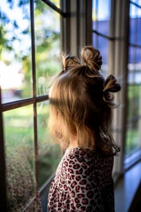Little girl with fun pigtails looks out a window Saint Paul, Minnesota, United States R_MZGL260722C-2083216-01 ,model released, Symbolfoto ,property released