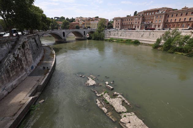 (260805) -- ROME, Aug. 5, 2026 -- This photo taken on Aug. 5, 2026 shows the Tiber River with low water level in Rome, Italy. Italy is battling its fourth major heatwave of the summer, with temperatures climbing above 40 degrees Celsius in parts of the country, and a record number of cities placed under the highest heat alert. Authorities are stepping up emergency measures amid mounting health, wildfire and agricultural concerns. The latest heatwave reached its peak on Monday, when the Health Ministry placed 25 of the country s 27 monitored cities under red alert, the highest warning level possible issued for extreme heat. ) ITALY-ROME-TIBER RIVER-HEAT WAVE WangxKaiyan 
