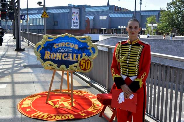 ABB RONCALLI- Werbeschild Mitarbeiter der Taufe der Look Zippo des Roncalli Sonderzug zu 50 Jahre Roncalli Jubilaeummstournee auf dem Gleis 1 Koeln Hauptbahnhof in Koeln am 05.AUGUST 2026 NRW Deutschland *** ABB RONCALLI promotional sign: Staff members at the Look Zippo christening ceremony for the Roncalli special train, marking the 50th anniversary of the Roncalli Jubilee Tour, on Track 1 at Cologne Central Station in Cologne on August 5, 2026, North Rhine-Westphalia, Germany