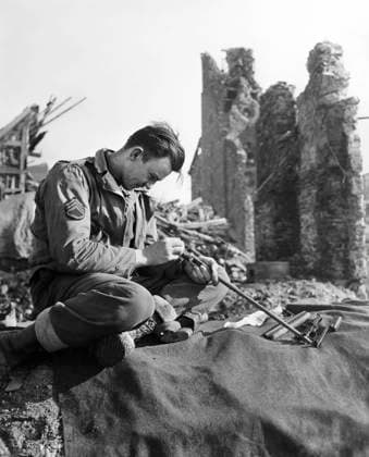 U.S. Staff Sargeant John S. Merger of Cullman, Alabama, 1st Infantry Division, U.S. First Army, taking time to clean his carbine in ruins of town on outskirts of Hurtgen Forest, North Rhine-Westphalia, Germany, U.S. Army Signal Corps, February 15, 1945  Copyright: xCircaxImagesx ghi-circa14469