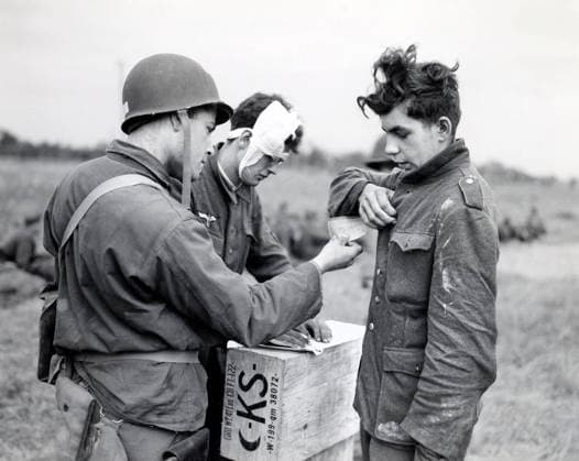 June 9, 1944, Normandy, France: American soldier making out identity tag for young German prisoner of war as another wounded Nazi supplies necessary information, Normandy, France, U.S. Army Signal Corps, June 9, 1944 France  - ZUMAg145 19440609_zap_g145_001 Copyright: xJTxVintagex