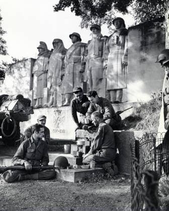 September 1, 1944, Verdun, France: Group of American soldiers cooking dinner on GI stove under World War I memorial, near Verdun, France, U.S. Army Signal Corps, September 1, 1944 Verdun France  - ZUMAg145 19440901_zap_g145_001 Copyright: xJTxVintagex