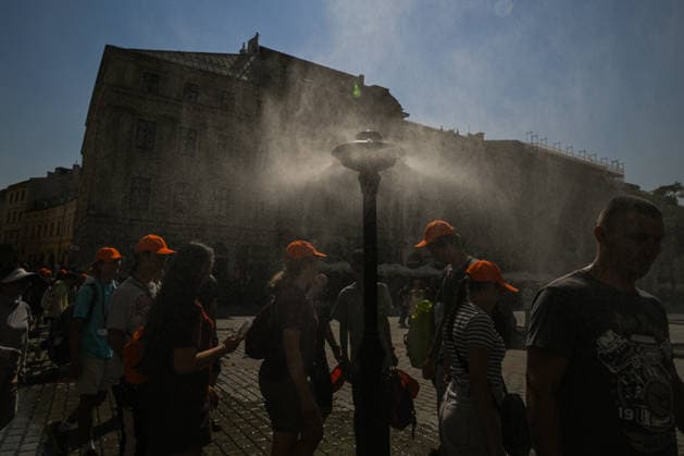 Krakow Hits 39Â°C As Severe Heatwave Triggers Red Weather Alerts Across Poland KRAKOW, POLAND - AUGUST 5: A group of youth marchers wearing matching orange caps passes a municipal water misting post in the Main Market Square (Rynek GÅ‚owny) during an intense heatwave on August 5, 2026, in Krakow, Poland. The Institute of Meteorology and Water Management (IMGW) kept its highest third-degree red alert active across the Lesser Poland Voivodeship as temperatures reached a peak of 39Â°C (102.2Â°F). Krakow Poland  Copyright: xArturxWidakx originalFilename: widak-krakowhi260805_np8v3.jpg