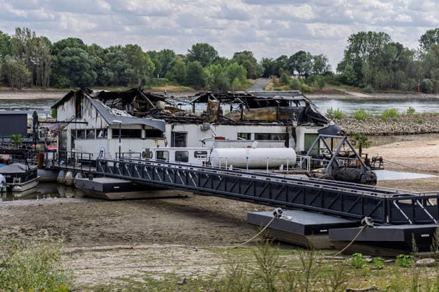 Sürther Bootshaus in Köln einen Tag nach dem Großbrand Ein Tag nach dem Großbrand: Das Sürther Bootshaus in Köln-Sürth, ein beliebtes Ausflugslokal und Restaurant direkt am Rhein, liegt in Trümmern bei dem Feuer am 04.08.2026 brannte vor allem der Dachbereich vollständig aus. Rund 100 Einsatzkräfte der Feuerwehr waren im Großeinsatz, verletzt wurde niemand, die Brandursache ist weiterhin unklar. Köln Sürth Nordrhein-Westfalen Deutschland *** The Sürth Boathouse in Cologne, One Day After the Major Fire One day after the major fire, the Sürth Boathouse in Cologne-Sürth, a popular destination for day trips and a restaurant right on the Rhine, lies in ruins following the fire on August 4, 2026. The roof area, in particular, bur Copyright: xMarcxJohnx