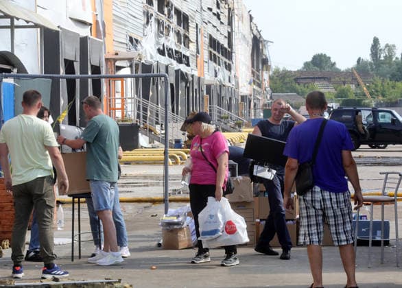 People salvage belongings, monitors, documents and boxes after an overnight Russian missile strike on a logistics complex in the village of Chaiky, Kyiv region, Ukraine, August 5, 2026. A direct hit triggered a large-scale fire that destroyed the main warehouse hub. Parking areas and freight vehicles also caught fire. (Photo by Volodymyr Tarasov Ukrinform) Russian missile strike hits logistics complex in Kyiv region  Copyright: xVolodymyrxTarasovx